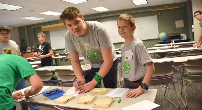 4-H teen standing with younger 4-H youth