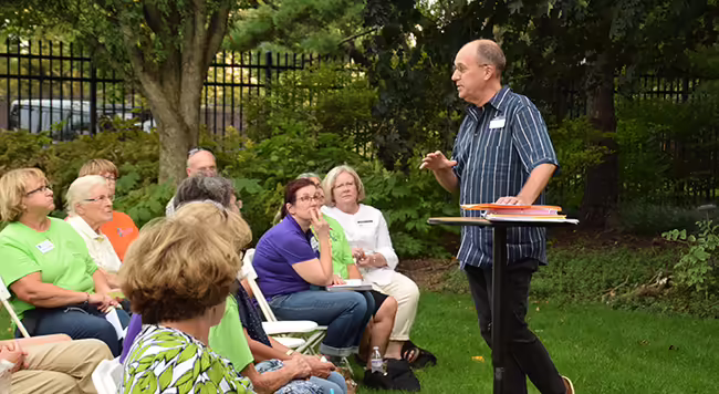 Ian Goslin standing a podium talking to a group