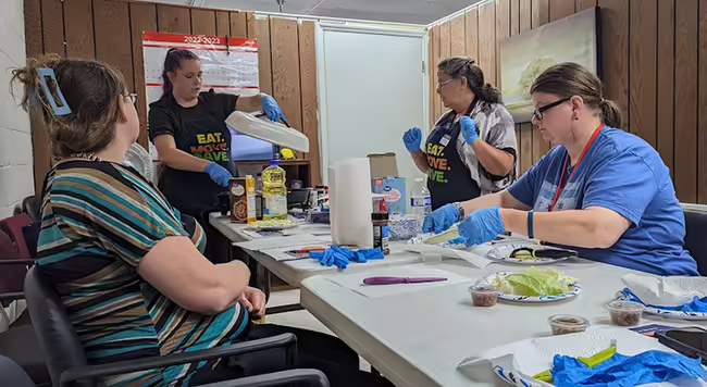 adults around a table with cooking utensils