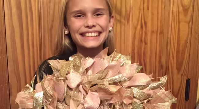 girl holding ribbon wreath